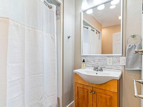 La salle de bains est pourvue d'un lavabo et d'une douche avec un miroir. dans l'établissement Cheerful 2-bedroom Home Near UP and St. Johns, à Portland