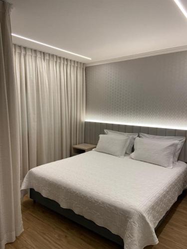 a bedroom with a large bed with white sheets at Flat Hotel in Sao Paulo