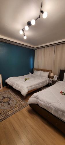 a bedroom with two beds and a blue wall at Jung Stay 신정역 1분 in Seoul