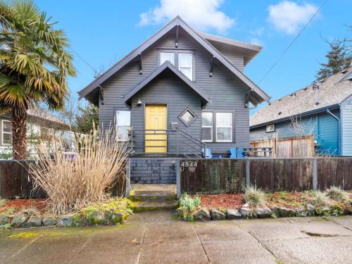 a gray house with a yellow door at Casa del Sol - Walk to Alberta Arts District in Portland