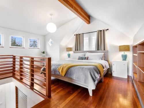 a bedroom with a bed and a wooden floor at Casa del Sol - Walk to Alberta Arts District in Portland