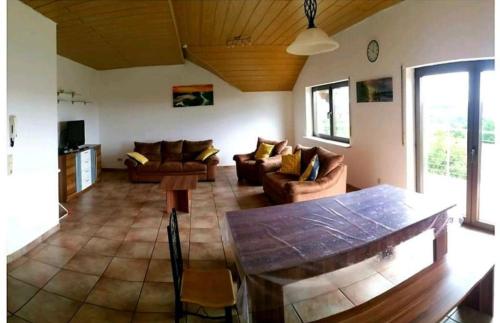 uma sala de estar com sofás e uma mesa em Ferienwohnung Teresa em Tholey