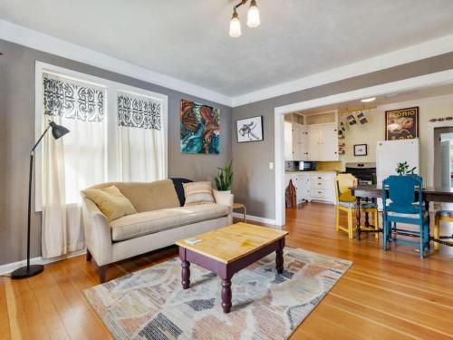 a living room with a couch and a table at Charming 1909 St Johns Bungalow in Portland