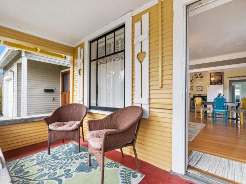two chairs sitting on the front porch of a house at Charming 1909 St Johns Bungalow in Portland