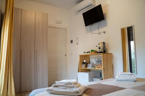1 Schlafzimmer mit 2 Betten und einem TV an der Wand in der Unterkunft L'angolo di Acitrezza in Acitrezza