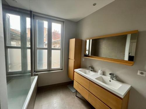 y baño con lavabo, bañera y espejo. en Appartement superbe Rooftop 70m2 Clermont Ferrand, en Clermont-Ferrand