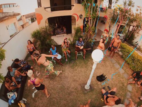 a group of people sitting in a yard playing a video game at Vibe House Arraial in Arraial do Cabo