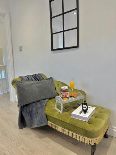 a living room with a green couch with a table at Luxurious family home in West Midlands in Northfield