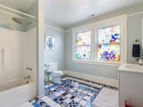 een badkamer met een bad, een toilet en een raam bij Art Deco Oasis - Stylish 2BD with Den, Office, Garden and Dip Pool in Portland
