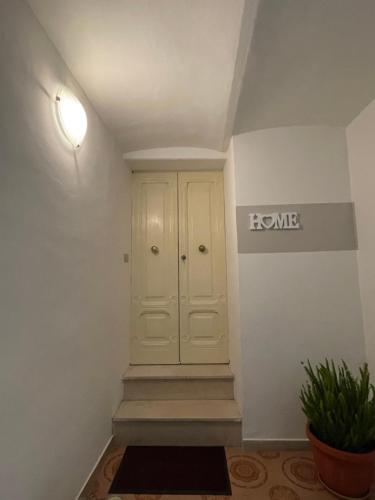 ランチャーノにあるLA CASETTA DI LORENZOの白いキャビネットと階段のある廊下