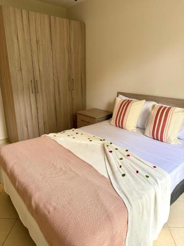 a bedroom with two beds with pillows at Coco Boho Beach Condo in Coco