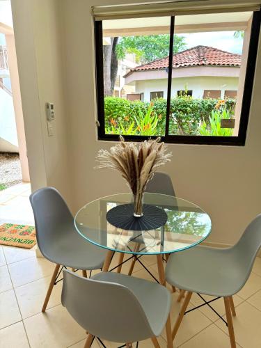 a dining room with a glass table and chairs at Coco Boho Beach Condo in Coco