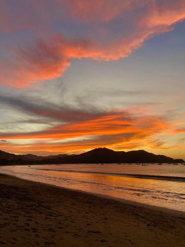 a sunset on a beach with a cloudy sky at Coco Boho Beach Condo in Coco