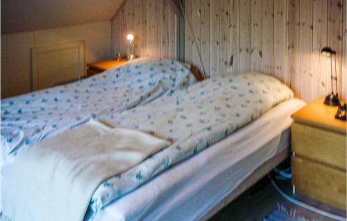 ein großes Bett in einem Schlafzimmer mit einer Holzwand in der Unterkunft 3 Bedroom Beautiful Home In Tistrup in Tistrup