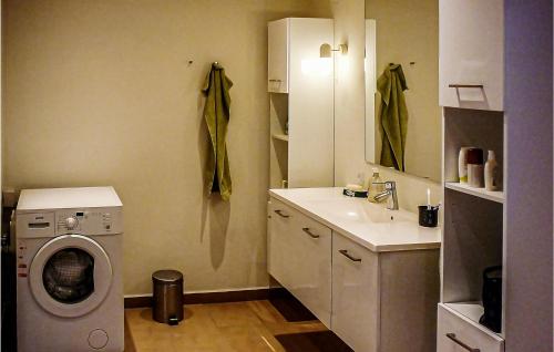 ein Badezimmer mit einer Waschmaschine und einem Waschbecken in der Unterkunft 3 Bedroom Beautiful Home In Tistrup in Tistrup