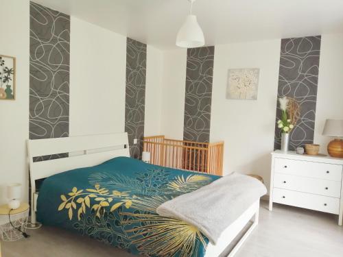 um quarto com uma cama com um edredão azul em Gîte de Landemeure, 10 couchages, accès PMR em Saint-Germain-du-Crioult