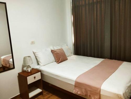 1 dormitorio con 1 cama y mesita de noche con lámpara en Apart Florencia 2 con cochera!, en Tacna