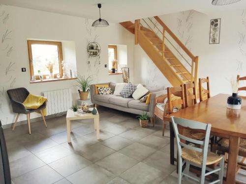 un salon avec un canapé et une table dans l'établissement Gîte de Landemeure, 10 couchages, accès PMR, à Saint-Germain-du-Crioult