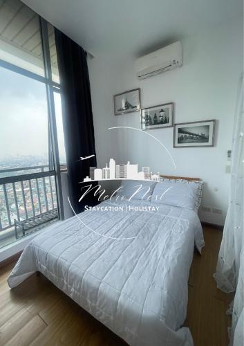 a bedroom with a white bed and a large window at MetroNest Sutherland in Manila