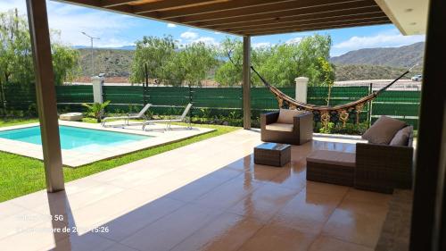 - un salon avec un hamac et une piscine dans l'établissement Laderas de Chacras vista Montaña en Barrio Privado, à Chacras de Coria