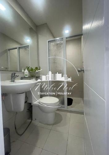 a bathroom with a toilet and a sink and a shower at MetroNest Sutherland in Manila