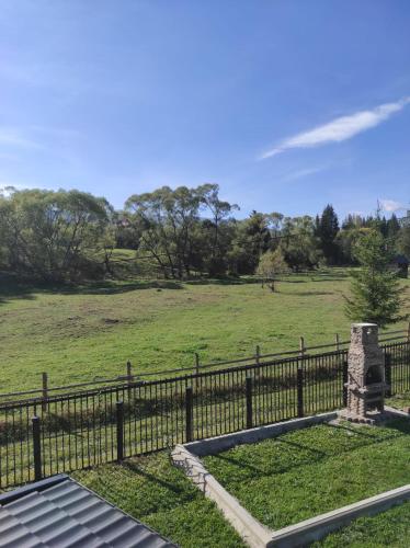 a fence in front of a field with a grass field at VILA RAISA in Neagra Şarului