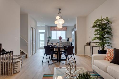 a living room and dining room with a table and a couch at Luxurious Modern Home With King Bed & Office in Calgary