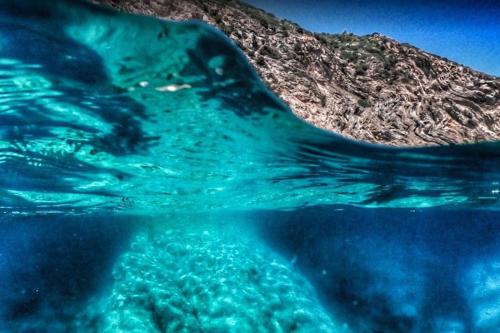 a close up of the water with a mountain in the background at BB24 - Cottage il Puntino in Porto Santo Stefano