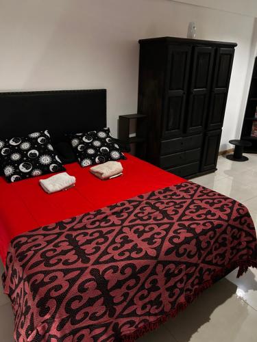 een slaapkamer met een rood bed met zwarte kussens bij Loft privado Berazategui in Berazategui