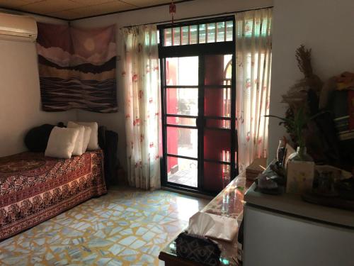 a bedroom with a bed and a window with a door at 紅色鐵門 in Taipei