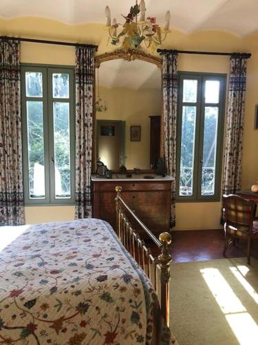 une chambre avec un lit et un grand miroir dans l'établissement Maison de 1820 dans un écrin de verdure de 2 ha, à Entrechaux