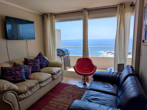 a living room with a couch and a view of the ocean at VISTAMAR COSTALILENES CONCON in Concón