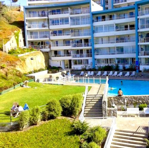 a large apartment building with a swimming pool and a hotel at VISTAMAR COSTALILENES CONCON in Concón