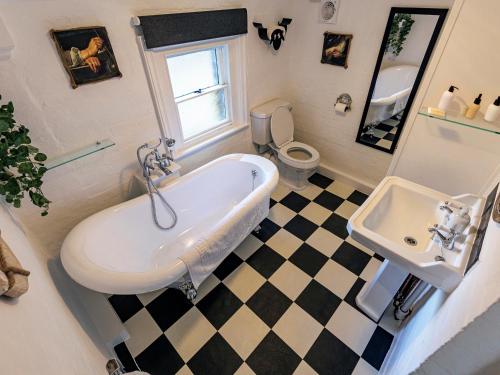 a bathroom with a tub and a toilet and a sink at Lytham Hall Gate House in Lytham St Annes