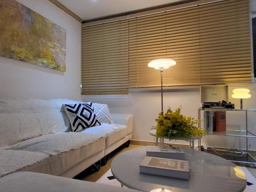 un soggiorno con un divano e un tavolo di Free pick-up, 4 Beds, near Gangnam, Hongdae, Subway 8 mins, Spacious a Seul