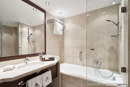 a bathroom with a tub and a sink and a shower at Atlantica Belvedere Resort - Adults Only in Kardamaina