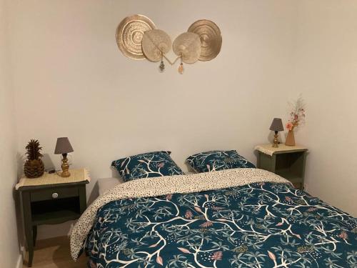 a bedroom with a bed and two night stands with lamps at Gîte Ty Guen à Paimpol in Paimpol