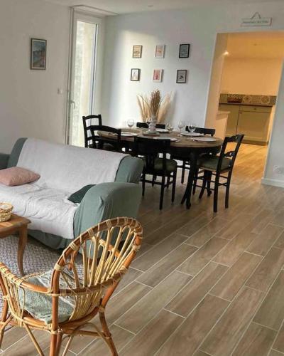 a living room with a couch and a table and chairs at Gîte Ty Guen à Paimpol in Paimpol