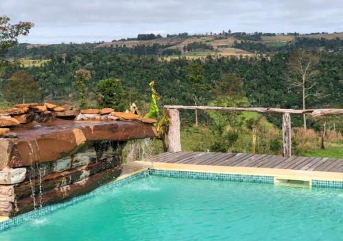 a swimming pool with a water fall at ECOLODGE PIEDRA Y AGUA in El Soberbio