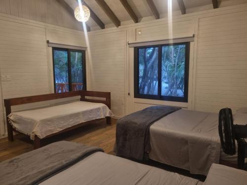 a room with two beds and two windows at Sol y Arena Xcalak in Xcalak