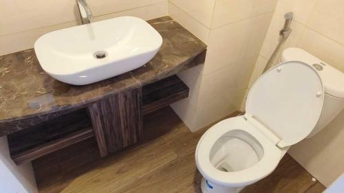 a bathroom with a white sink and a toilet at SleepRest @ NTC in Nagoya