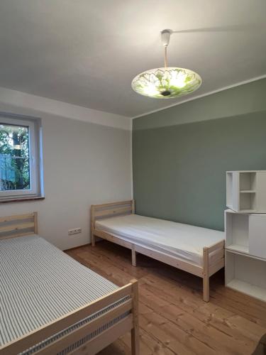 a room with two beds and a chandelier at Ferienhaus Melzower Waldhaus Montagewohnung in Melzow