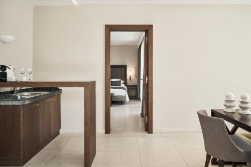 a kitchen and dining room with a table and a mirror at Atlantica Belvedere Resort - Adults Only in Kardamaina