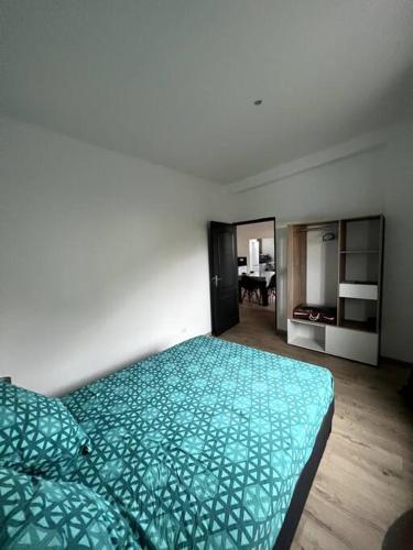 1 dormitorio con edredón verde en la cama en L'escale du sud sauvage, en Petite Île