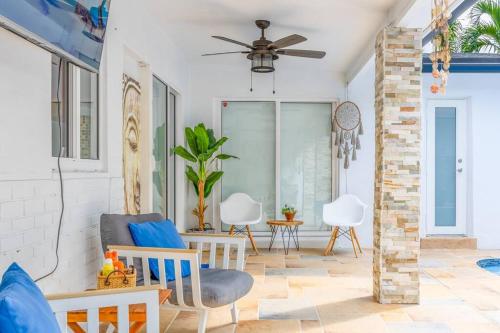 a living room with a ceiling fan and chairs at Casa Tropicana - Heated Pool, Game Room & Mins from beach in Hallandale Beach