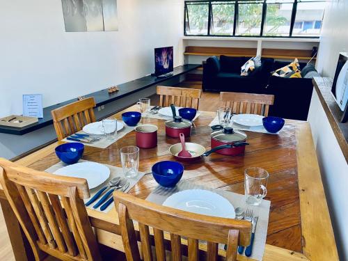 a wooden table with blue bowls and plates on it at Apartamento amplo a 4km do aeroporto internacional de Guarulhos Cecap in Guarulhos
