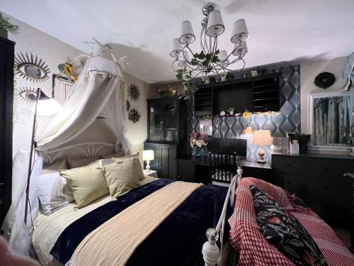 a bedroom with a canopy bed and a chandelier at Detached house a room in Essex in Waltham Abbey