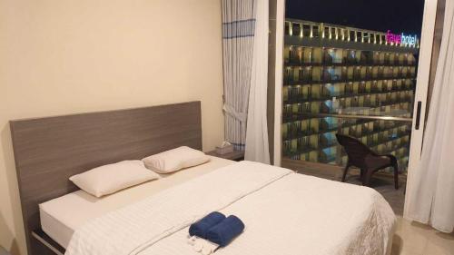 a bedroom with a large white bed and a window at SleepRest @ NTC in Nagoya