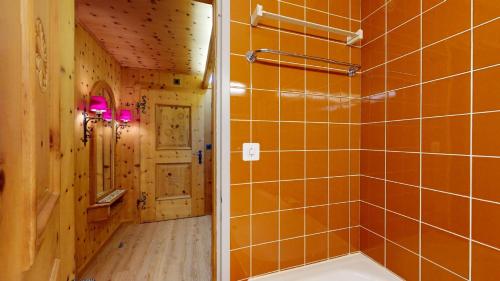 een badkamer met oranje betegelde muren en een bad bij Abitaziun Skyline 201 in St. Moritz