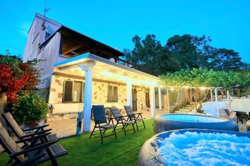 un patio trasero con bañera de hidromasaje y una casa en Villa Paradisea, en Bacoli